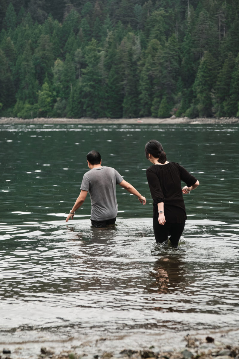 세례를 받기 위해 물속으로 걸어가는 두 사람의 사진