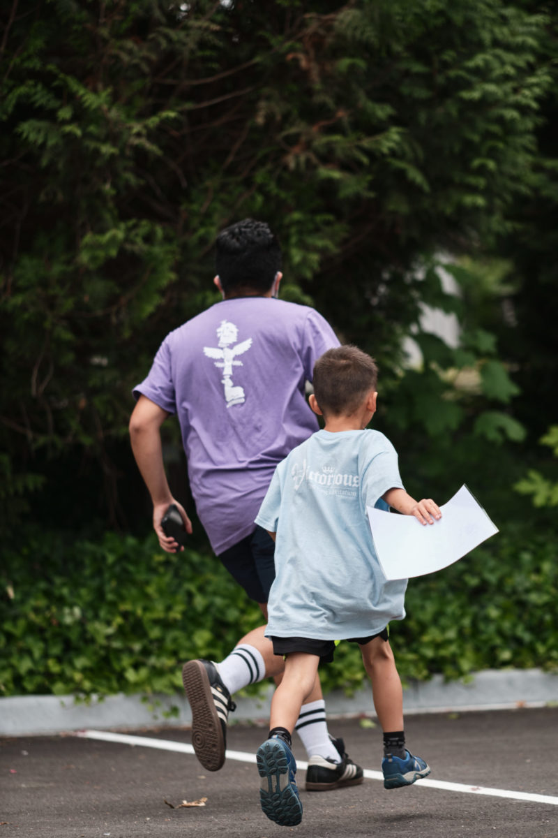 Photo of staff and child running at daycamp