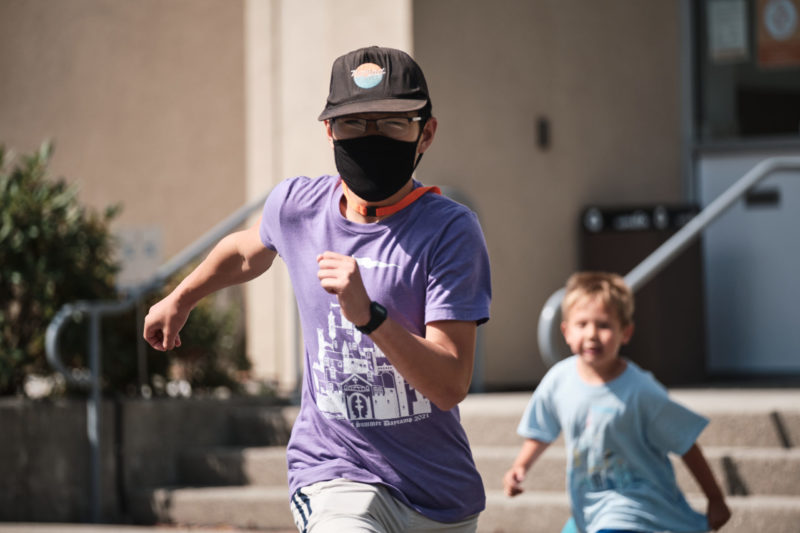 Photo of child chasing daycamp volunteer